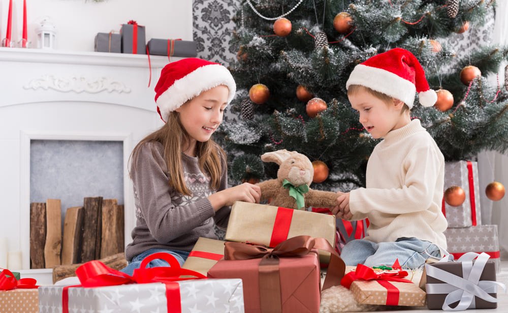 Copii deschizand cadourile de Craciun