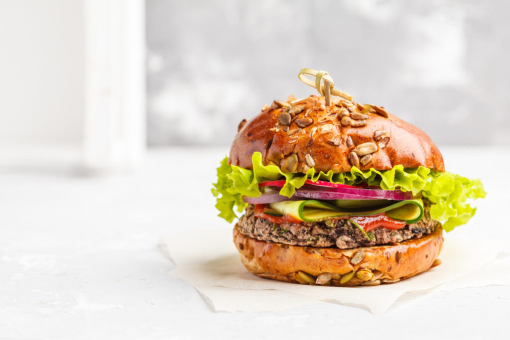 Burger vegetarian cu ciuperci si fasole rosie pe masa alba