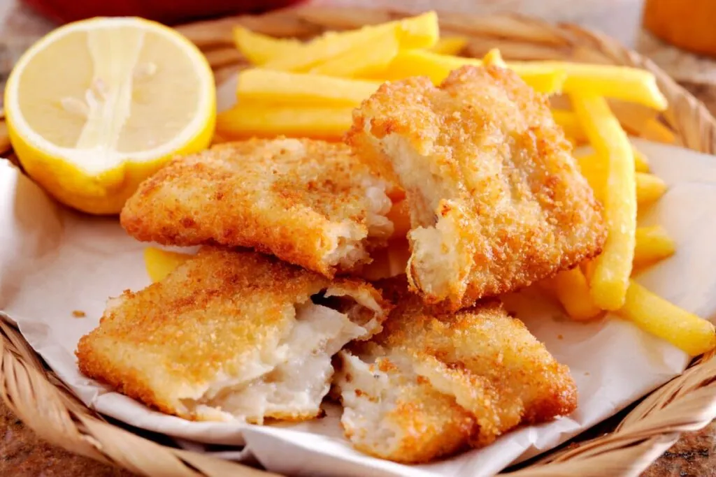 Fish and chips dupa reteta britanica servit pe hartie in cos impletit