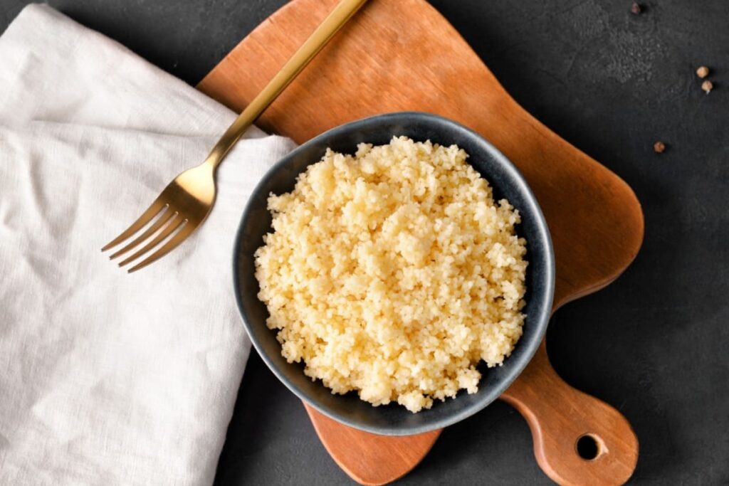 Bol cu cuscus fiert pe tocator din lemn