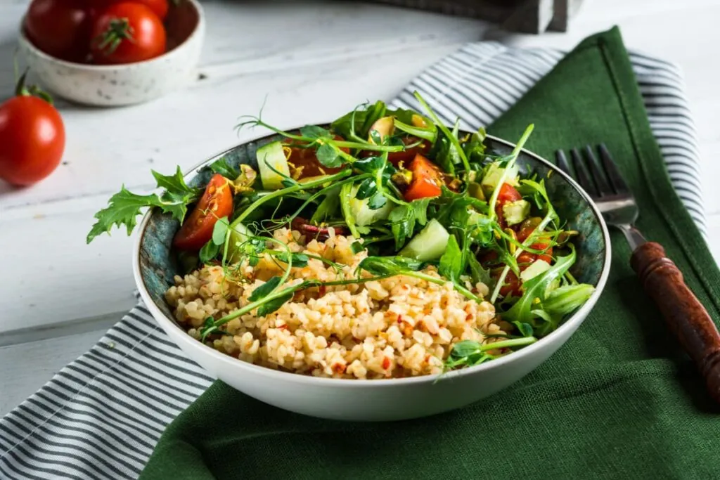 Bulgur cu salata de legume in bol pe servet de bucatarie