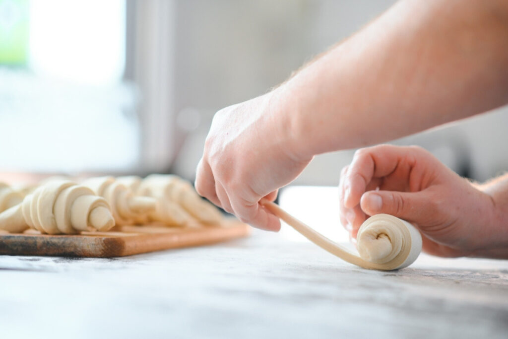 Femeie care ruleaza aluatul pentru croissante