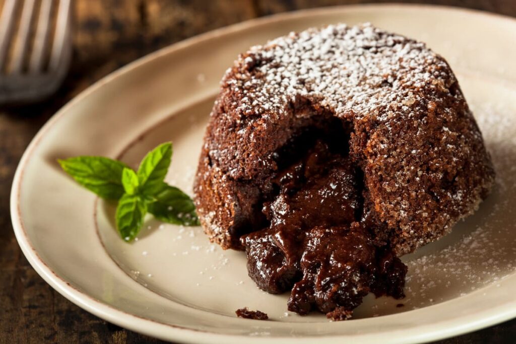 Prajitura lava cake decorata cu frunze de menta pe farfurie