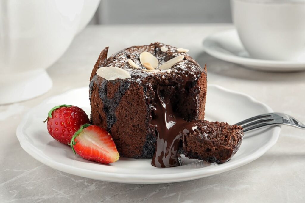 Prajitura lava cake pe farfurie alba cu capsuni