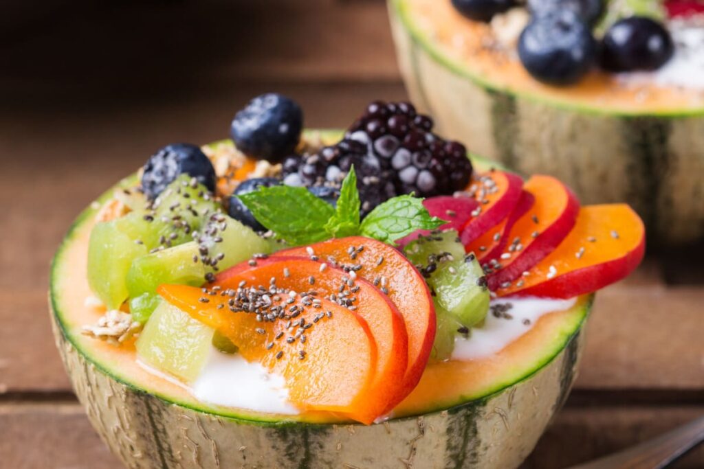 Salata de fructe servita in coaja de pepene galben cu seminte de chia si menta