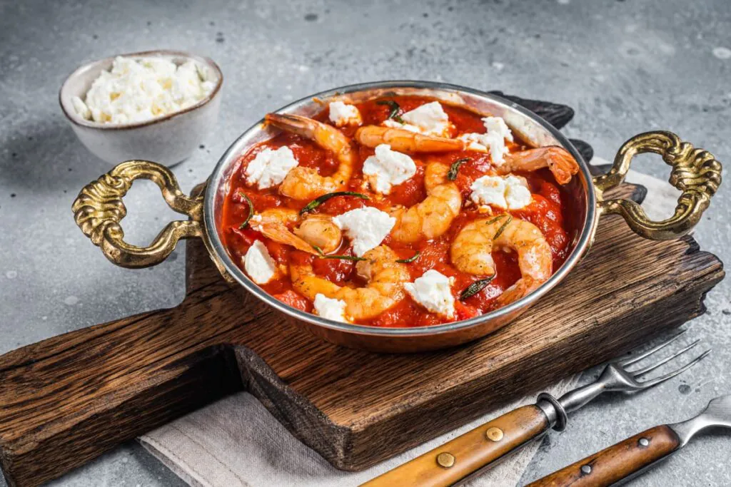 creveti Saganaki in tigaie pe tocator din lemn