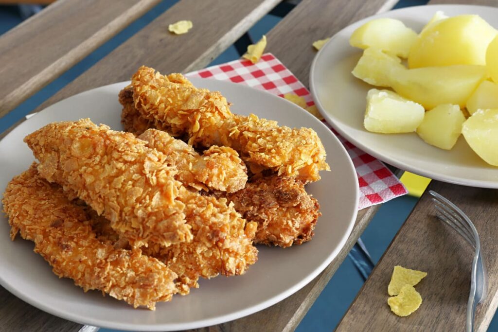 crispy strips cu fulgi de porumb pe farfurie alaturi de cartofi la cuptor