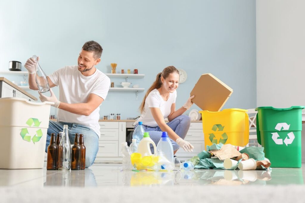 cuplu care sorteaza deseurile acasa