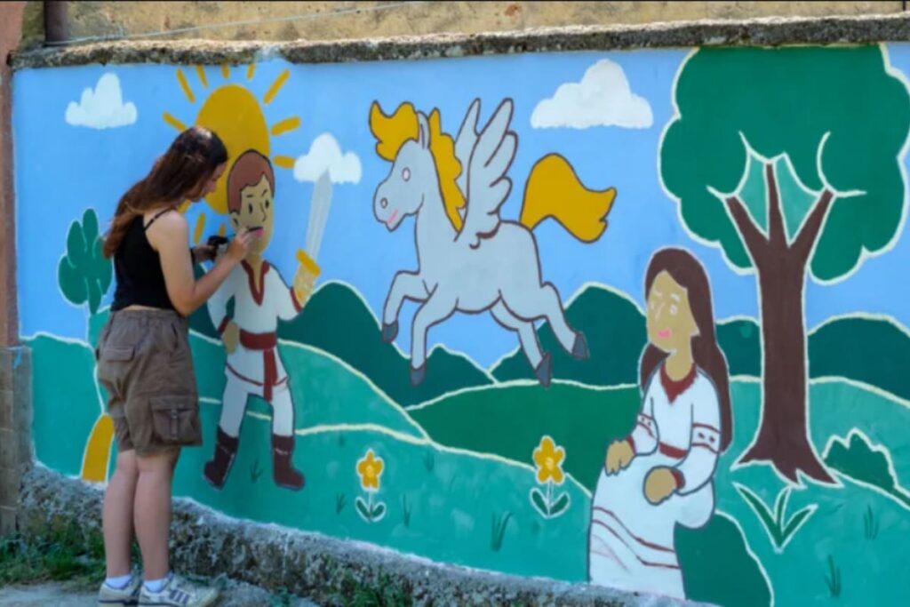 fata care picteaza un perete in cadrul proiectului Color the village Gradinari