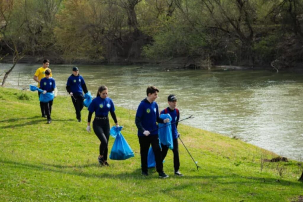 voluntari care ajuta la ecologizare pe marginea raului