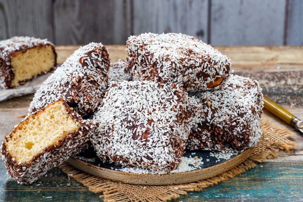 bucati de prajitura tavalita cu nuca de cocos pe farfurie rustica
