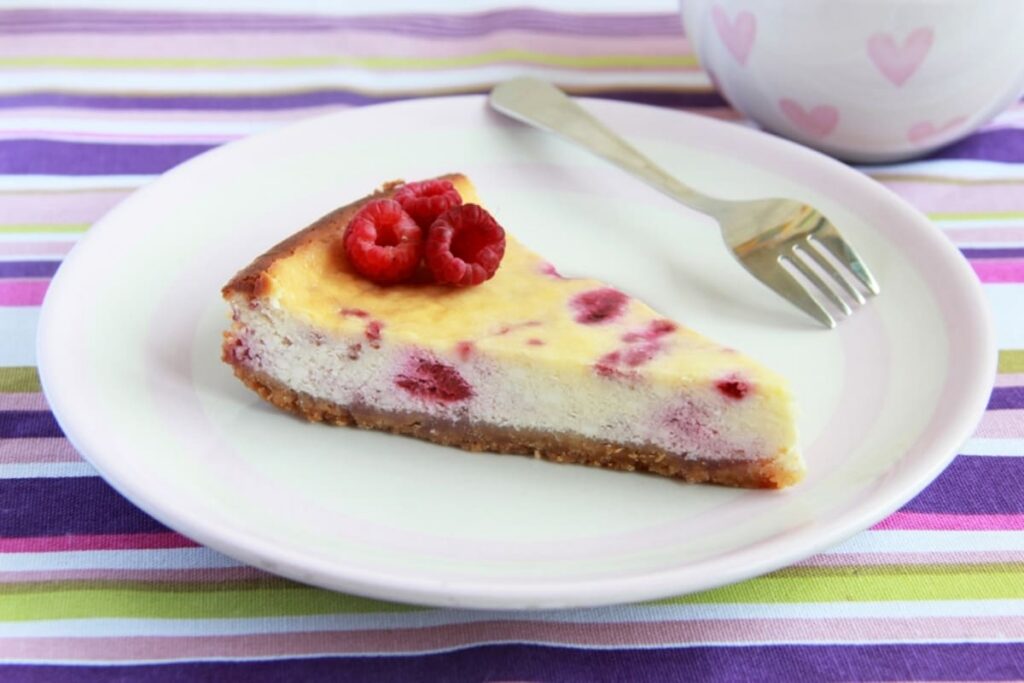 Tort cu zmeura si lamaie, decorat cu felii de lamaie si fructe proaspete