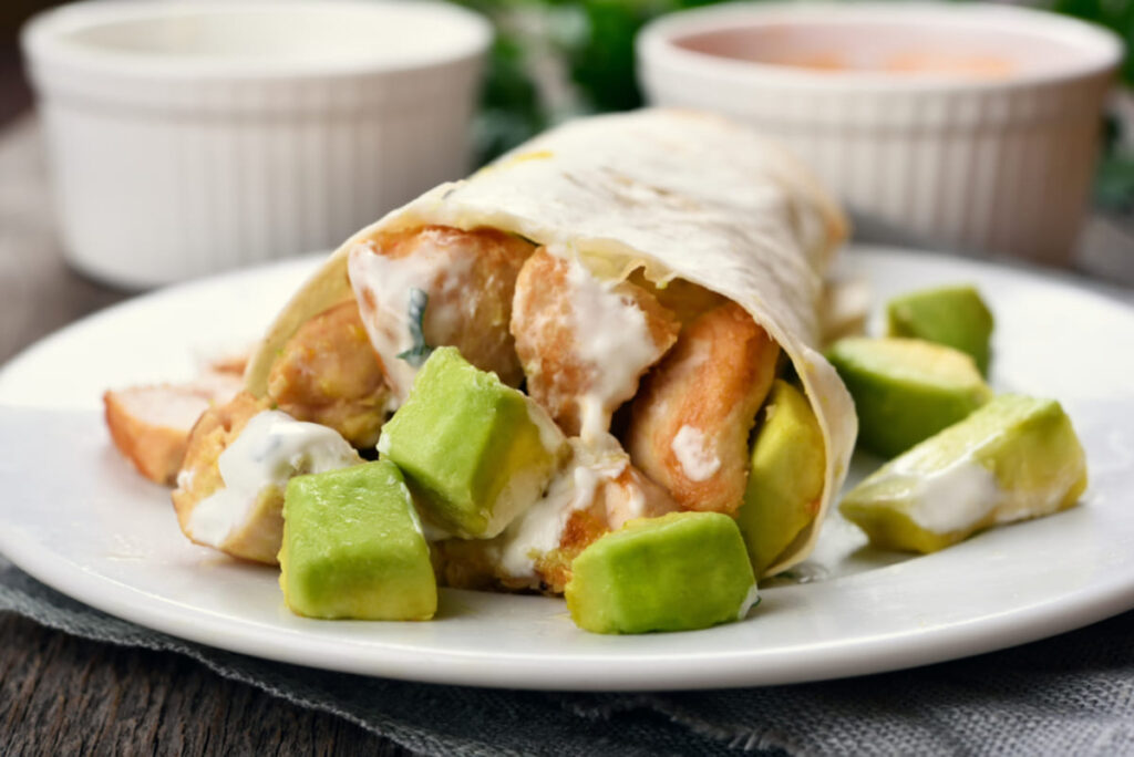 wrap cu pui și avocado servit cu sosuri